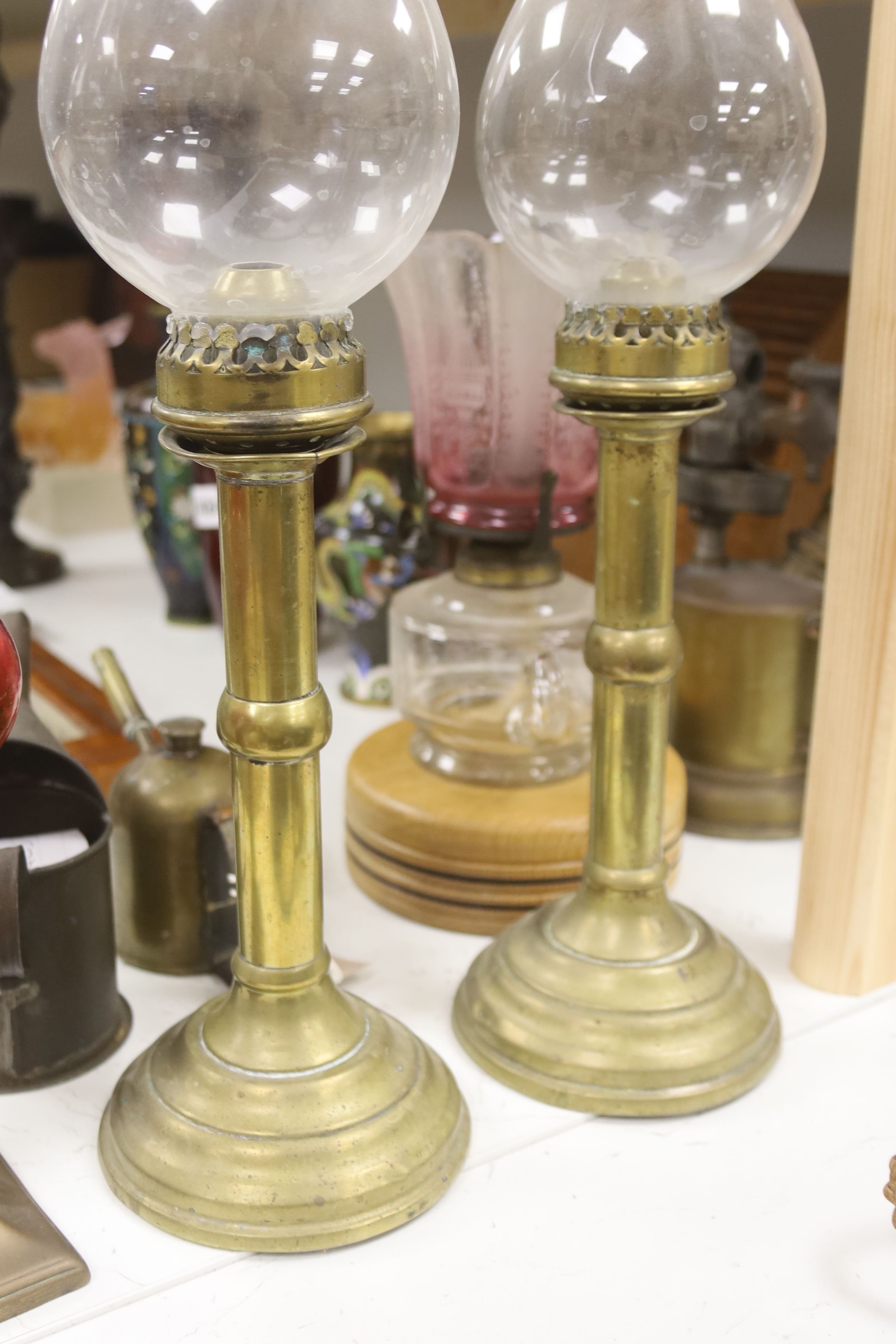 A pair of candle storm lamps, two oil lamps, a paint stripper, a jeweller's blow lamp and oil can, tallest 49cm